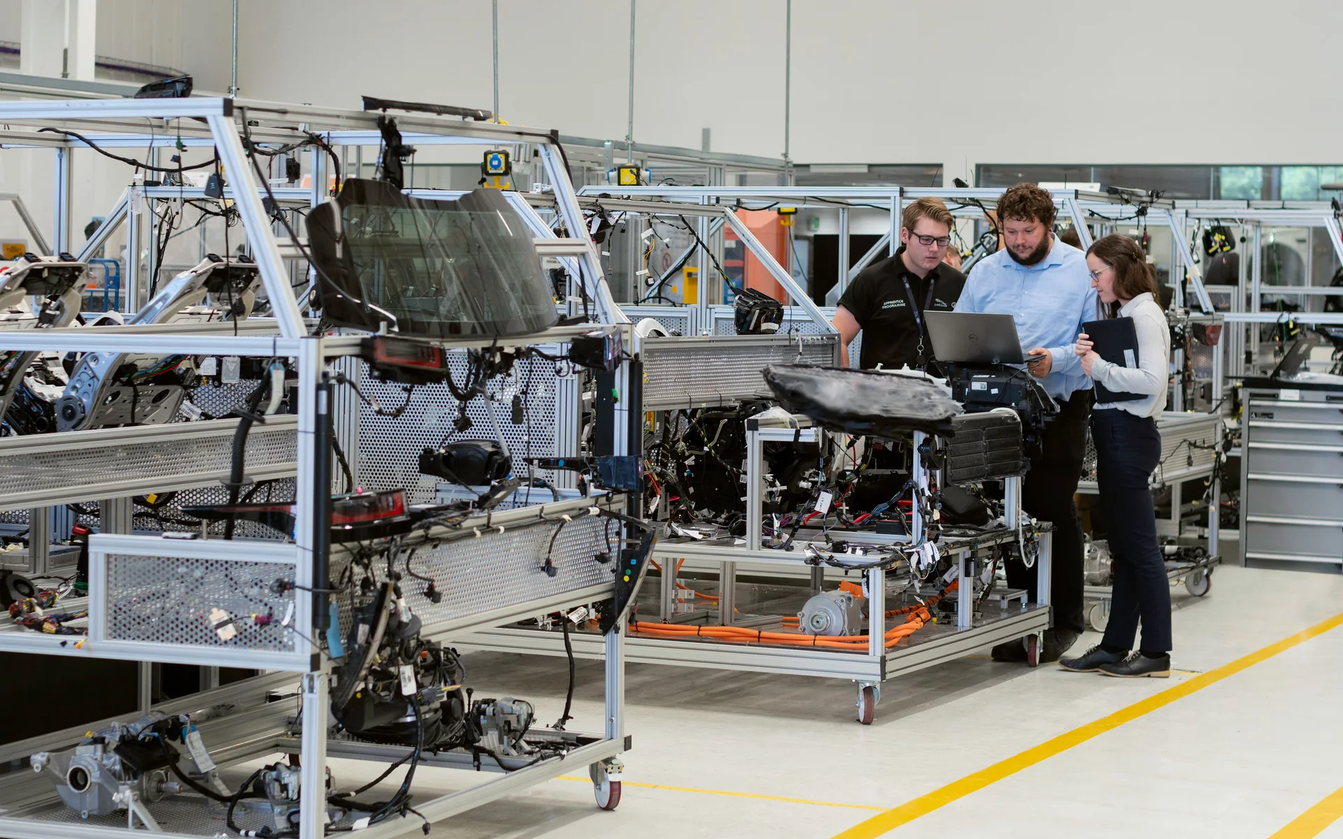 Engineering team working around connected manufacturing equipment in a modern production workshop